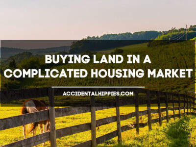 Text: Buying Land in a Complicated Housing Market, AccidentalHippies.com Image: field with wooden fence and horses grazing